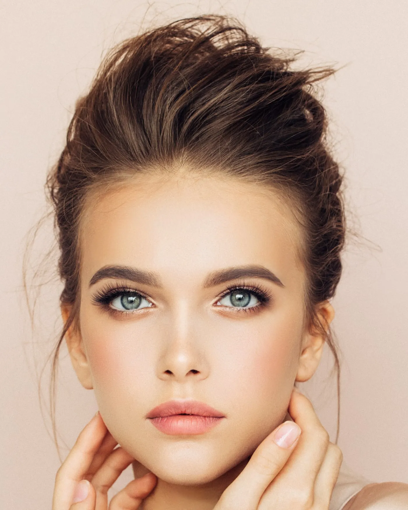 A woman with clear, even skin and her hair pinned up